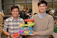 两个学生拿着一个玩具，他们修改了这个玩具，让残疾儿童更容易接触到.